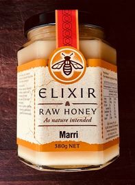 Elixir Raw Honey in jar on wood board