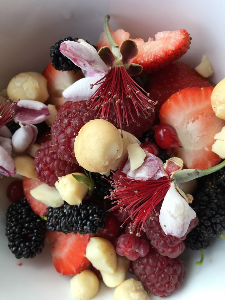 Berries, nuts and edible blossoms in a bowl